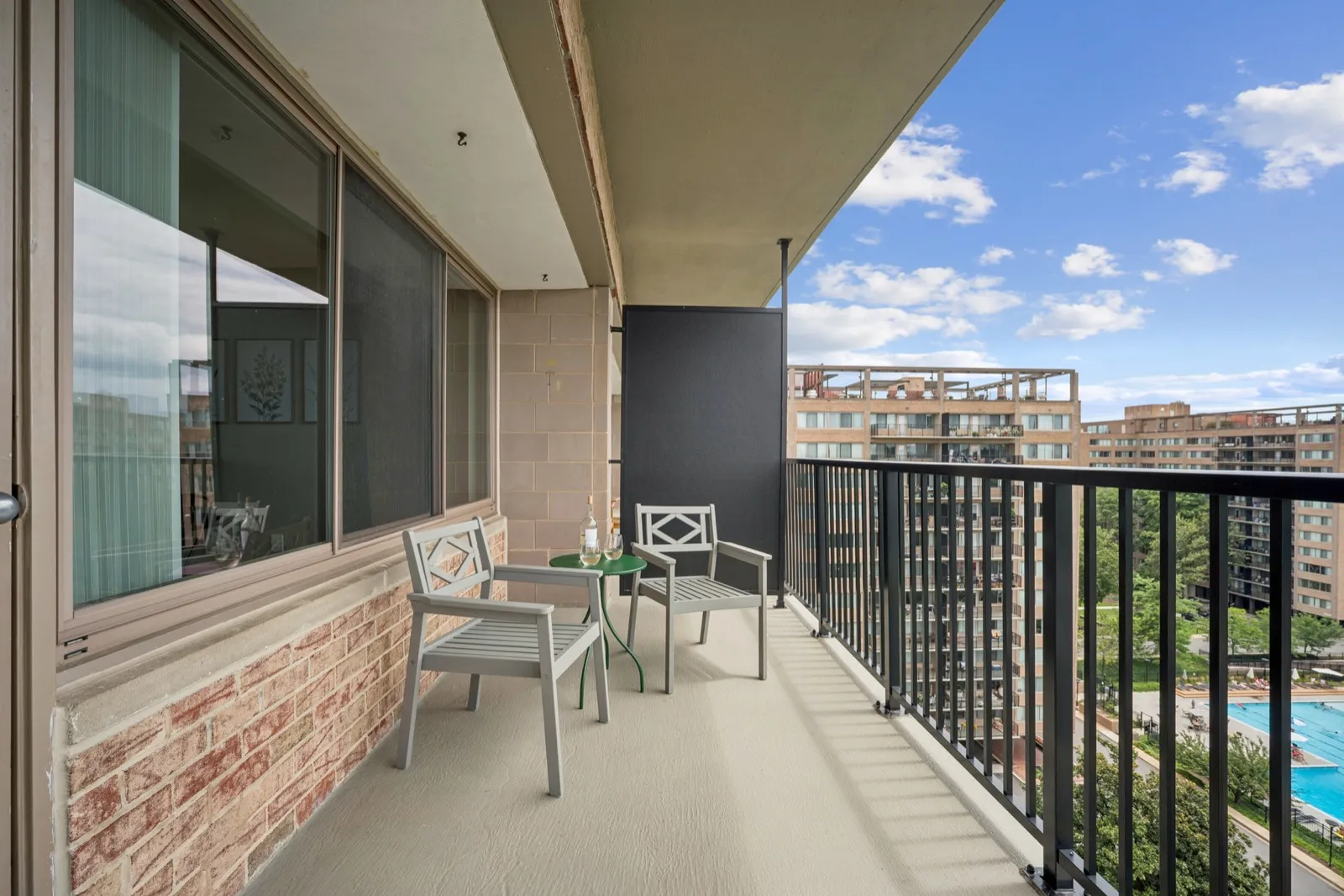 Private balcony with bistro seating and pool views at a Crystal City furnished apartment in Arlington VA
