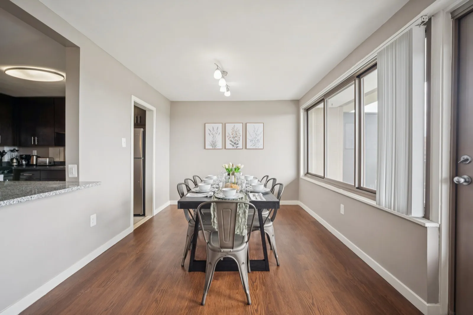 Dining table set for six with track lighting and window views in a Crystal City furnished rental