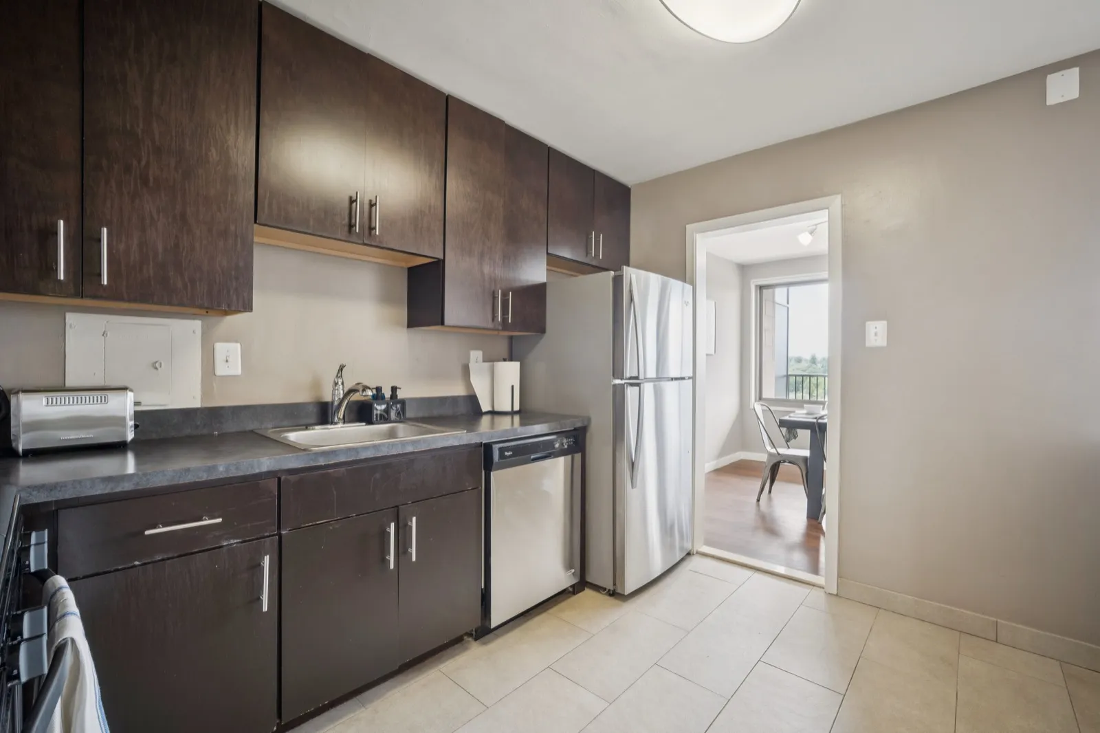 Fully equipped galley kitchen with dark cabinets and stainless steel appliances in an Arlington VA furnished apartment