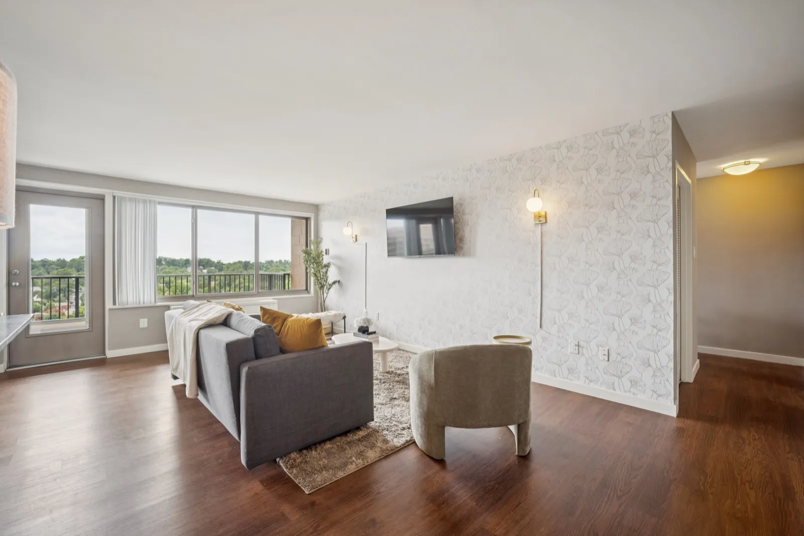 Open living space with modern furnishings and balcony access in a Crystal City corporate apartment