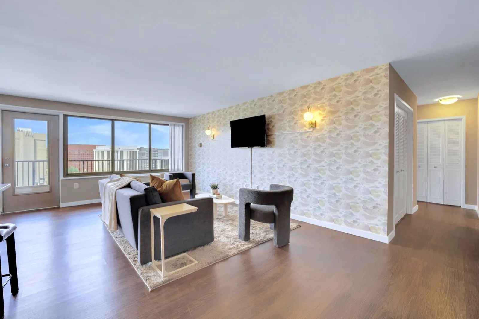 Living room with a sectional sofa, accent chair, and large windows in a Crystal City furnished apartment
