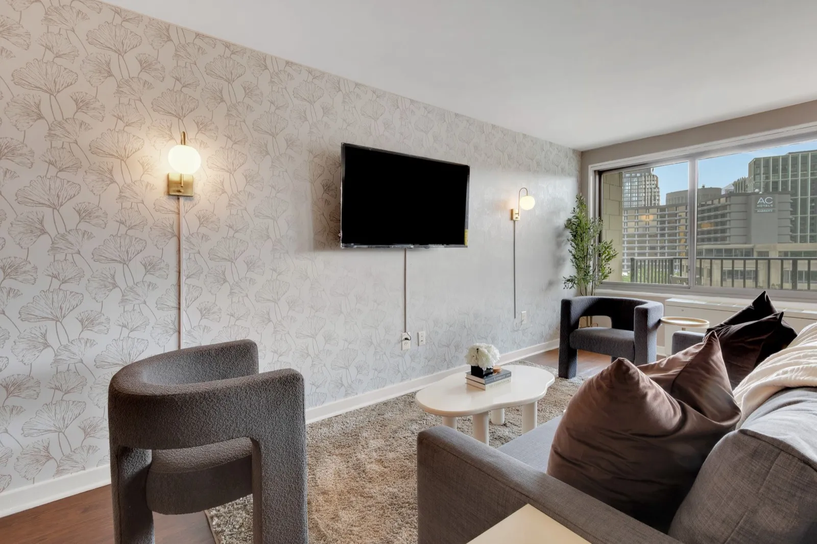 Living room with wall-mounted smart TV, designer wallpaper, and city skyline views in National Landing