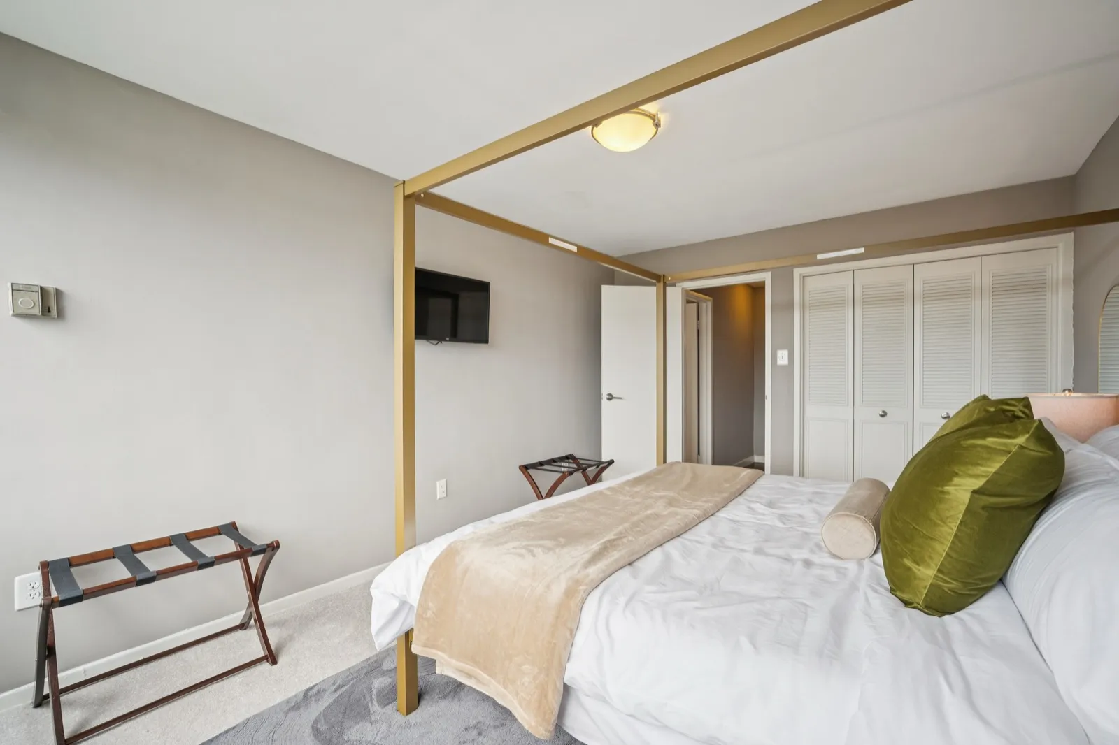 Primary suite with a canopy bed frame, designer pillows, and city views in Crystal City, Arlington VA
