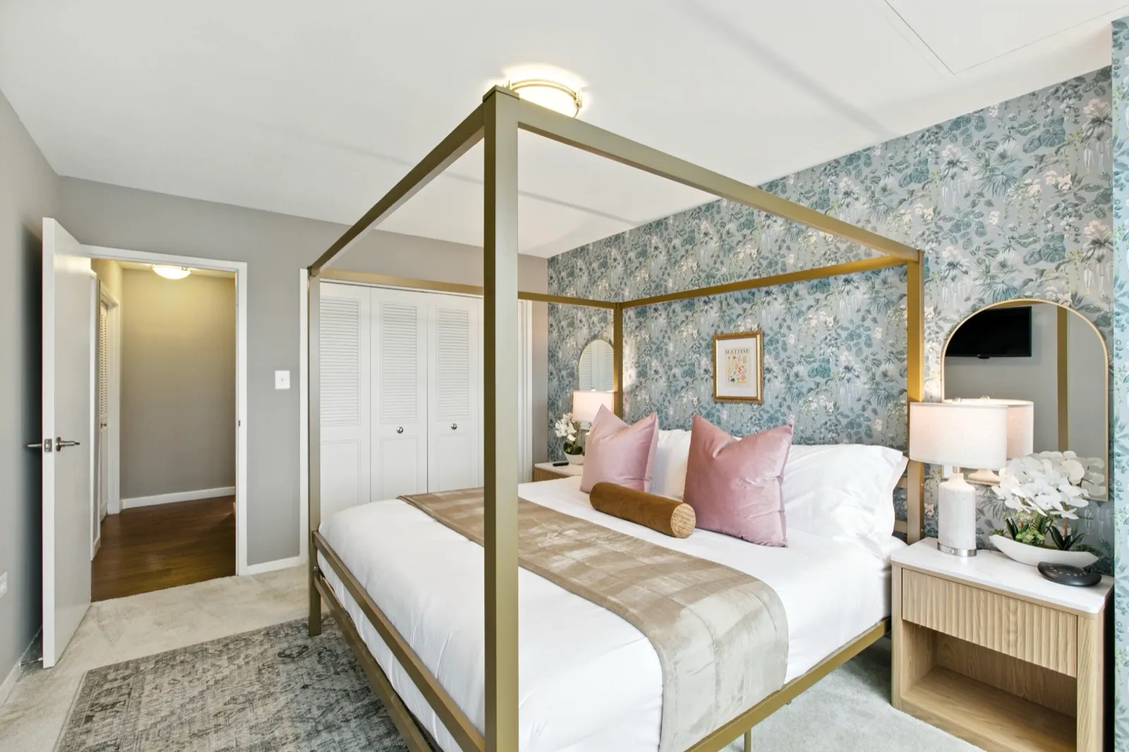 Luxury primary bedroom with a gold canopy bed and blue floral wallpaper in Crystal City, Arlington VA