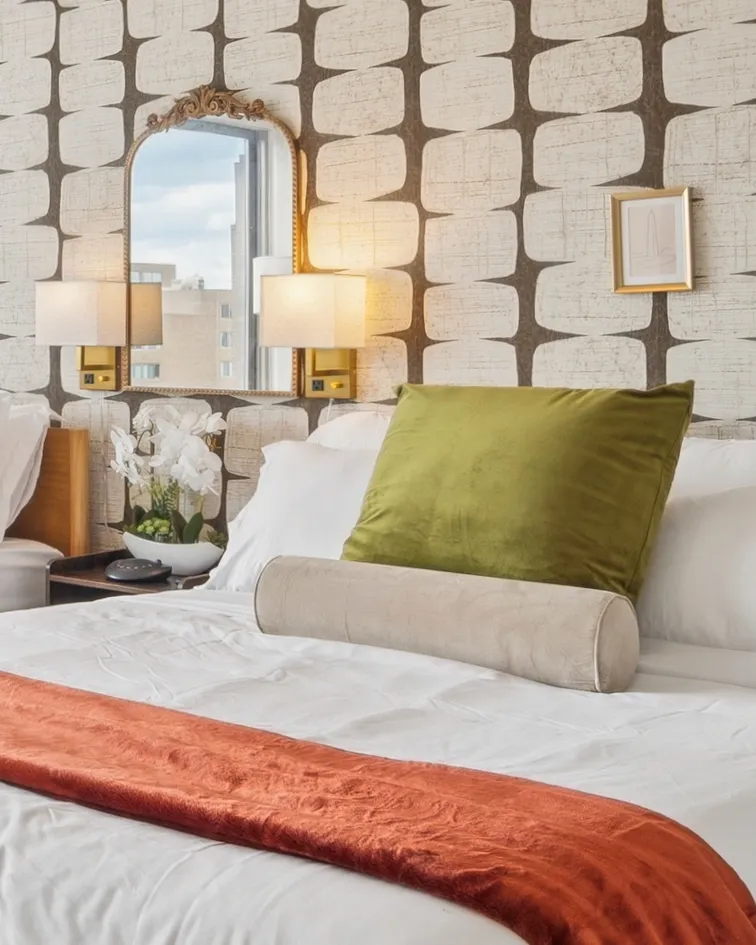 Designer bedroom with patterned accent wall, gold mirror and city view in The Greenline Vista — furnished corporate housing in Crystal City, Arlington VA