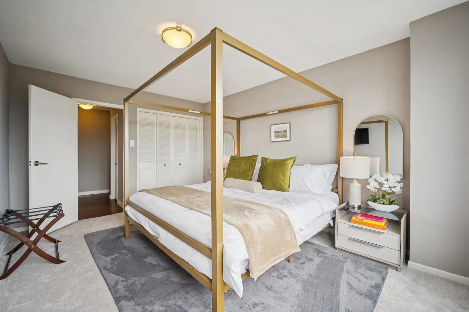 Primary bedroom with luxury bedding, accent wallpaper, and natural light in an Arlington VA furnished rental