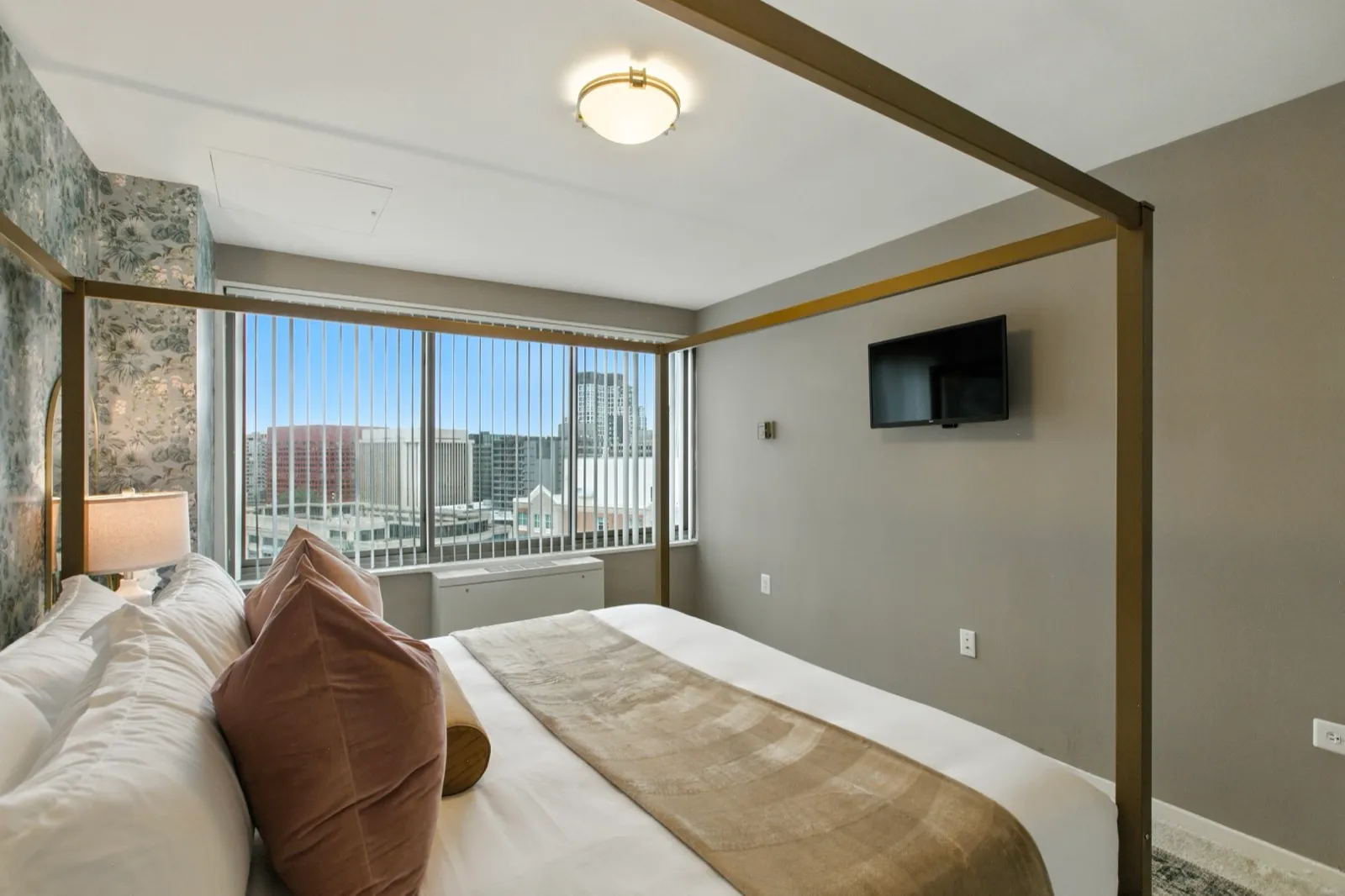 Primary suite with designer bedding, an accent wall, and city views in a Crystal City furnished rental
